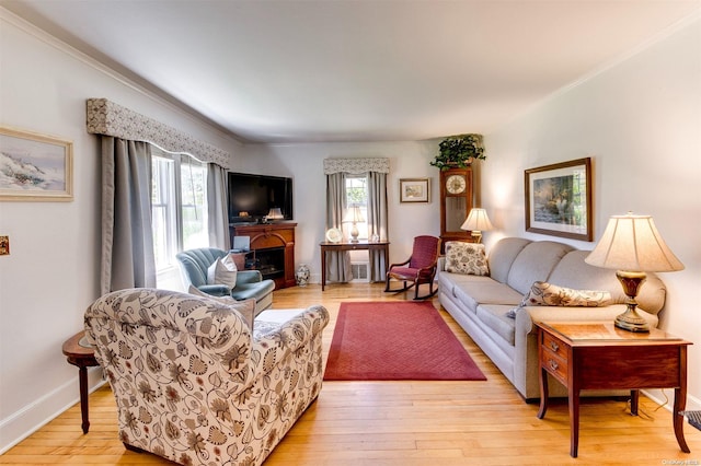 living room with light wood-type flooring and crown molding