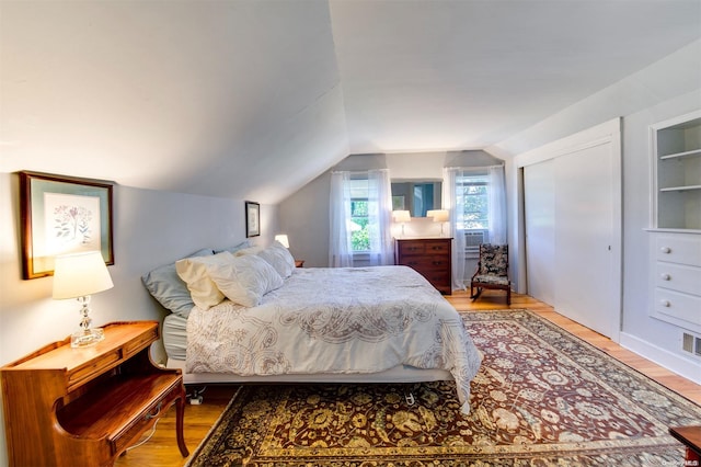 bedroom featuring wood-type flooring and vaulted ceiling