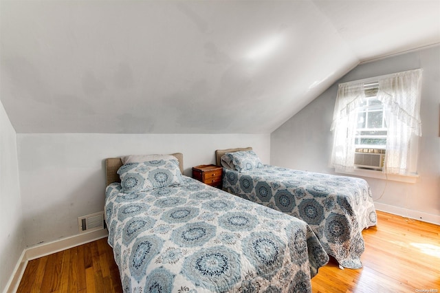 bedroom featuring hardwood / wood-style floors and lofted ceiling