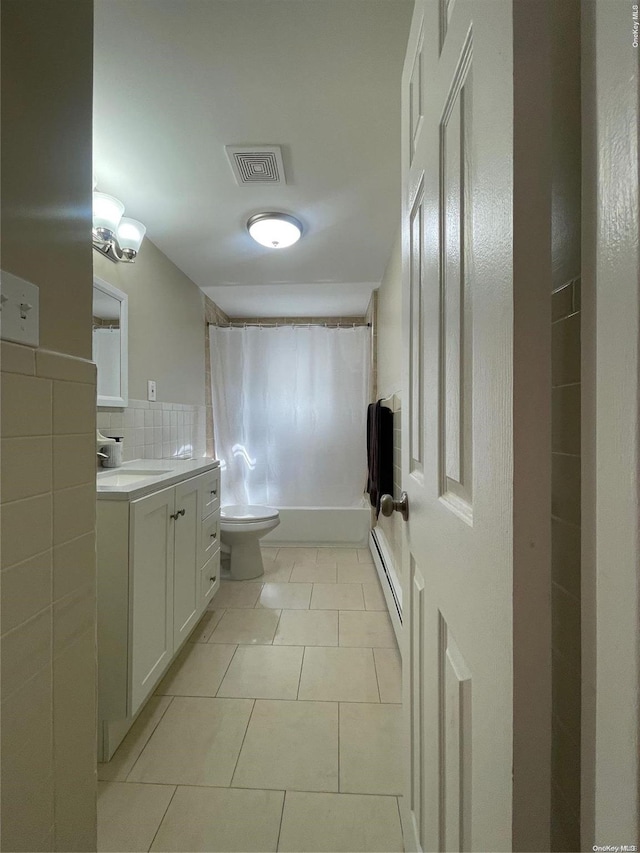 bathroom with tile patterned floors, vanity, a baseboard radiator, tile walls, and toilet