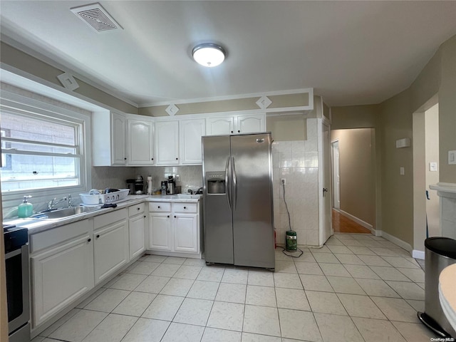 kitchen featuring white cabinets, sink, light tile patterned floors, and stainless steel appliances