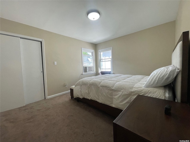 bedroom with a closet and dark colored carpet