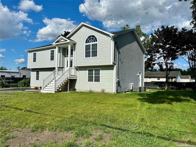 view of front of house with central AC and a front lawn