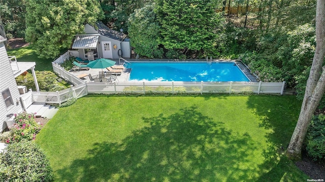 view of swimming pool featuring a lawn and an outbuilding