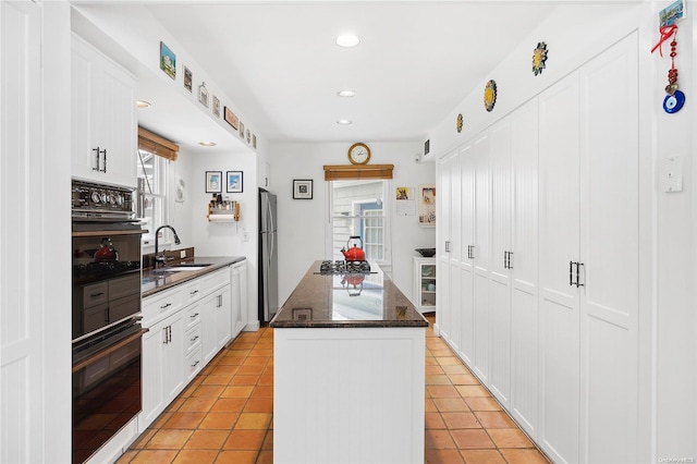 kitchen featuring sink, white cabinetry, and black appliances