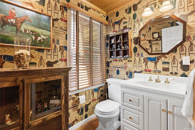 bathroom with vanity, toilet, and crown molding