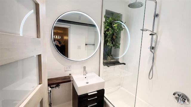 bathroom featuring vanity, decorative backsplash, and walk in shower