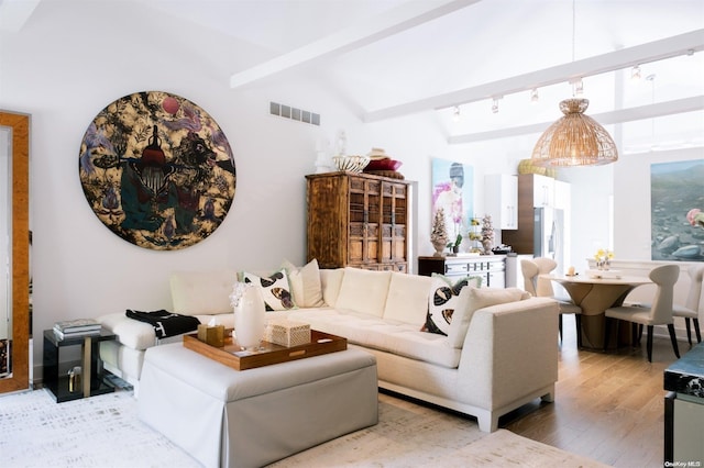 living room with vaulted ceiling with beams, hardwood / wood-style flooring, and track lighting