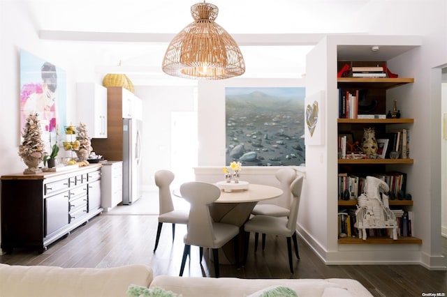 dining area with a chandelier, built in shelves, and dark wood-type flooring