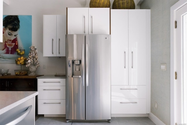 kitchen featuring white cabinetry, stainless steel fridge, and light tile patterned flooring