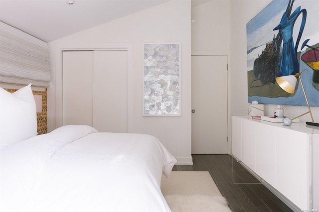 bedroom featuring a closet, dark hardwood / wood-style floors, and vaulted ceiling