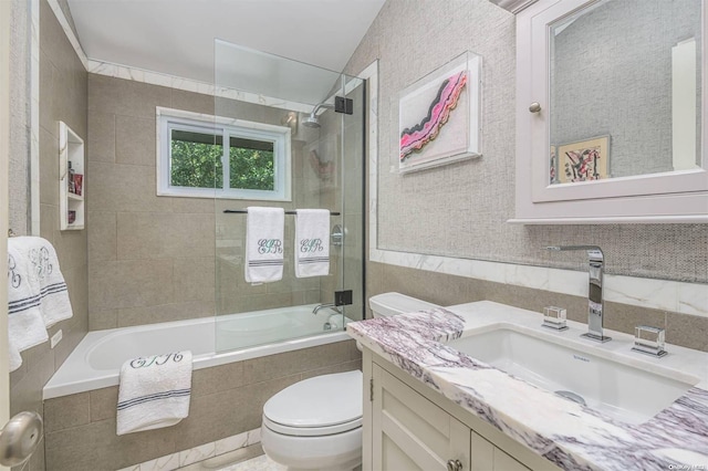 full bathroom featuring vanity, bath / shower combo with glass door, and toilet