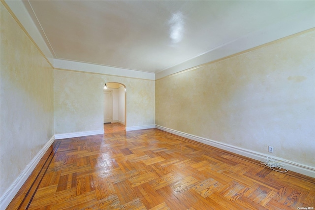 spare room with crown molding and light parquet floors