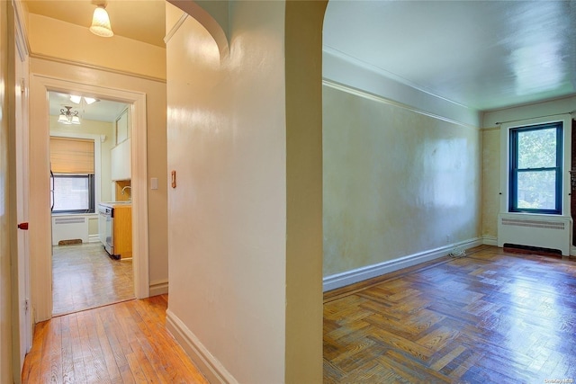 76-66 Austin St Unit 2-O, Forest Hills, NY 11375 - hall with radiator heating unit, arched walkways, light wood-type flooring, and baseboards