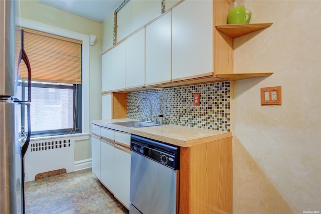 kitchen featuring appliances with stainless steel finishes, tasteful backsplash, white cabinetry, and sink