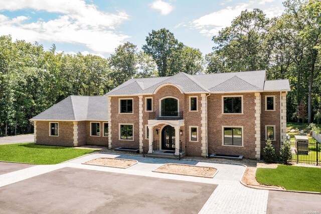 view of front of property featuring a balcony and a front yard