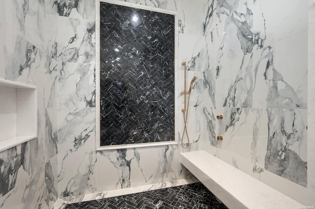 bathroom featuring a tile shower and tile walls