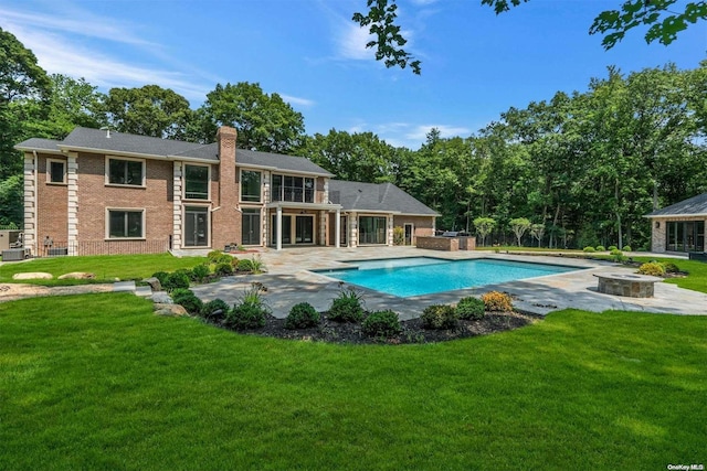 view of swimming pool with an outdoor fire pit, a patio area, and a lawn