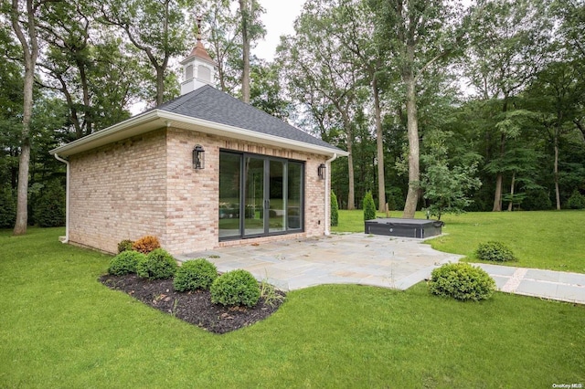 rear view of property featuring a lawn and a patio