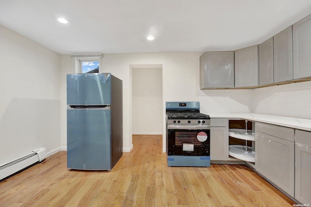 kitchen with stainless steel appliances, light hardwood / wood-style flooring, a baseboard heating unit, and gray cabinetry