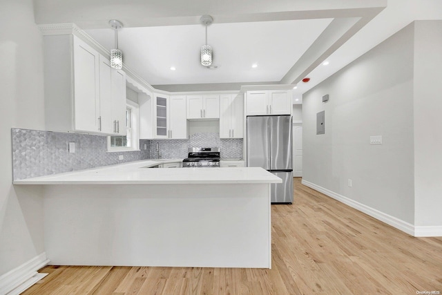 kitchen with kitchen peninsula, appliances with stainless steel finishes, pendant lighting, light hardwood / wood-style floors, and white cabinetry