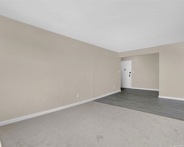 spare room featuring dark colored carpet