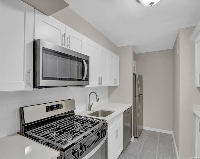 kitchen featuring backsplash, sink, white cabinets, and stainless steel appliances