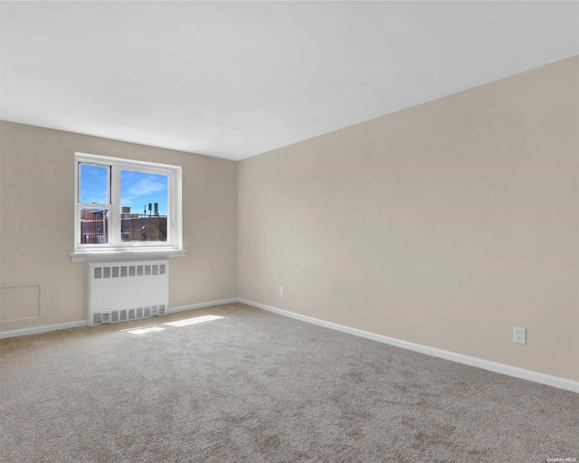 unfurnished room with carpet and radiator