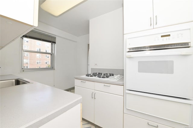 kitchen featuring white cabinets, white appliances, and sink