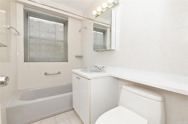 full bathroom with tile patterned floors, tiled shower / bath, vanity, and toilet