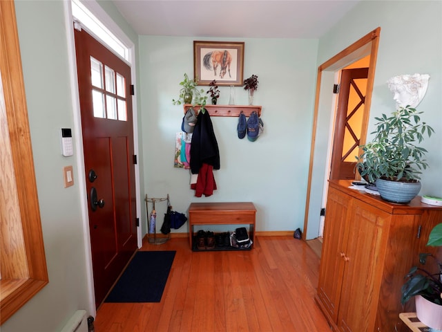 foyer featuring light wood-type flooring and a baseboard heating unit