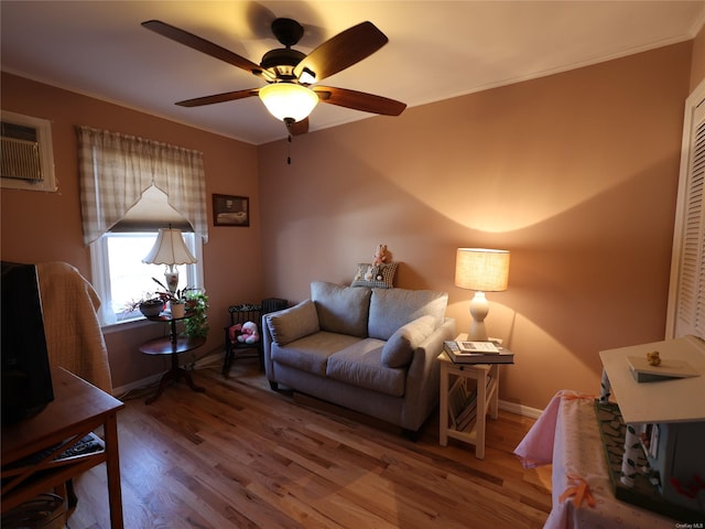 living room featuring a wall mounted AC, ceiling fan, hardwood / wood-style floors, and ornamental molding