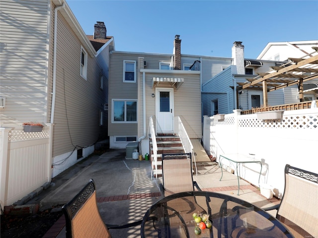 rear view of house featuring a pergola and a patio