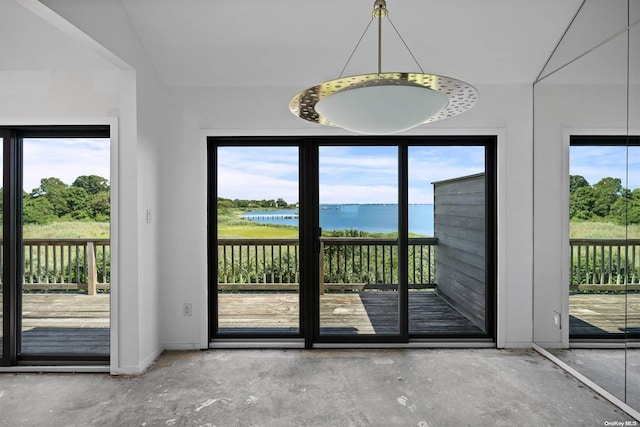 doorway to outside featuring a wealth of natural light, a water view, and concrete floors