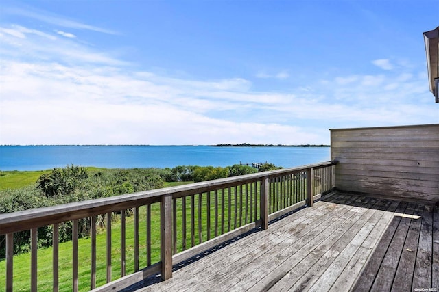 wooden terrace featuring a water view and a lawn