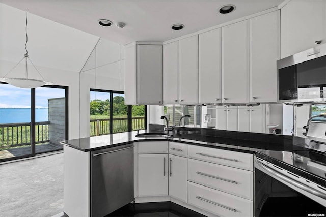 kitchen featuring sink, white cabinets, kitchen peninsula, a water view, and appliances with stainless steel finishes