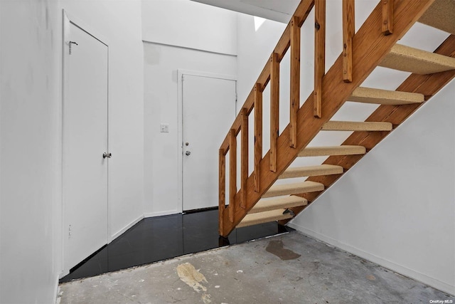 staircase featuring concrete floors