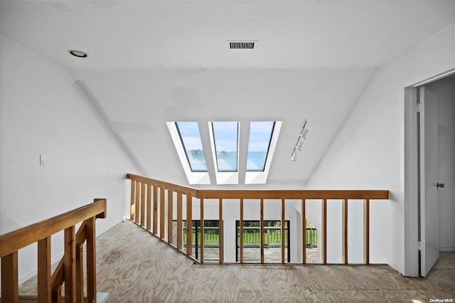 hallway featuring lofted ceiling with skylight