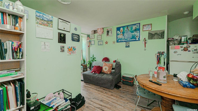 bedroom with light wood-type flooring and white refrigerator