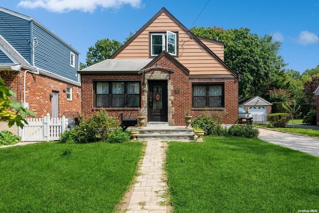 view of front of house featuring an outbuilding, a garage, and a front yard