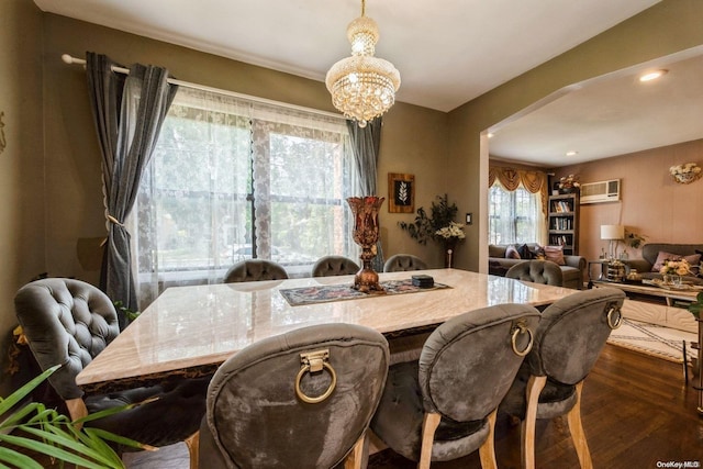 dining room featuring a chandelier, dark hardwood / wood-style flooring, and a wall mounted AC