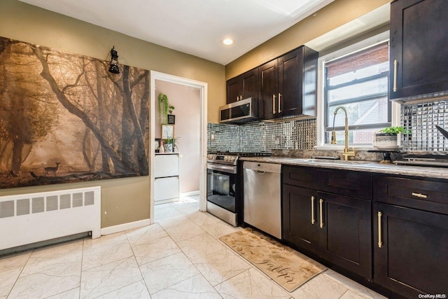 kitchen featuring backsplash, sink, dark brown cabinetry, radiator heating unit, and stainless steel appliances