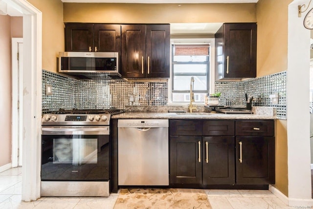 kitchen with dark brown cabinetry, decorative backsplash, sink, and stainless steel appliances