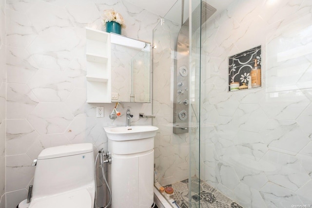 bathroom with tiled shower, vanity, toilet, and tile walls