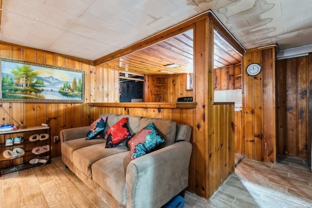 living room with light hardwood / wood-style floors and wooden walls