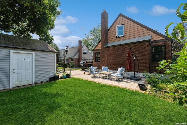 rear view of house with a lawn, a patio, and an outdoor structure