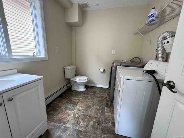 laundry room with washing machine and dryer, a baseboard radiator, and sink