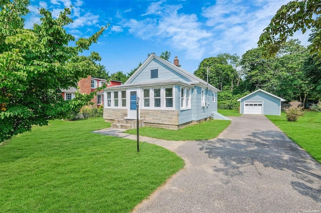 view of front of property with a garage, an outbuilding, and a front lawn