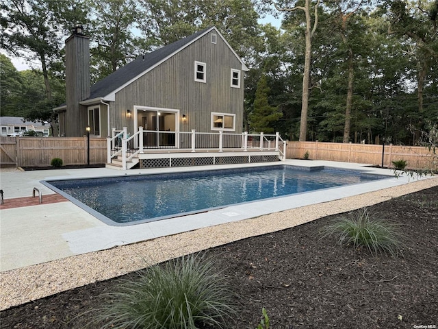 view of swimming pool featuring a patio and a deck