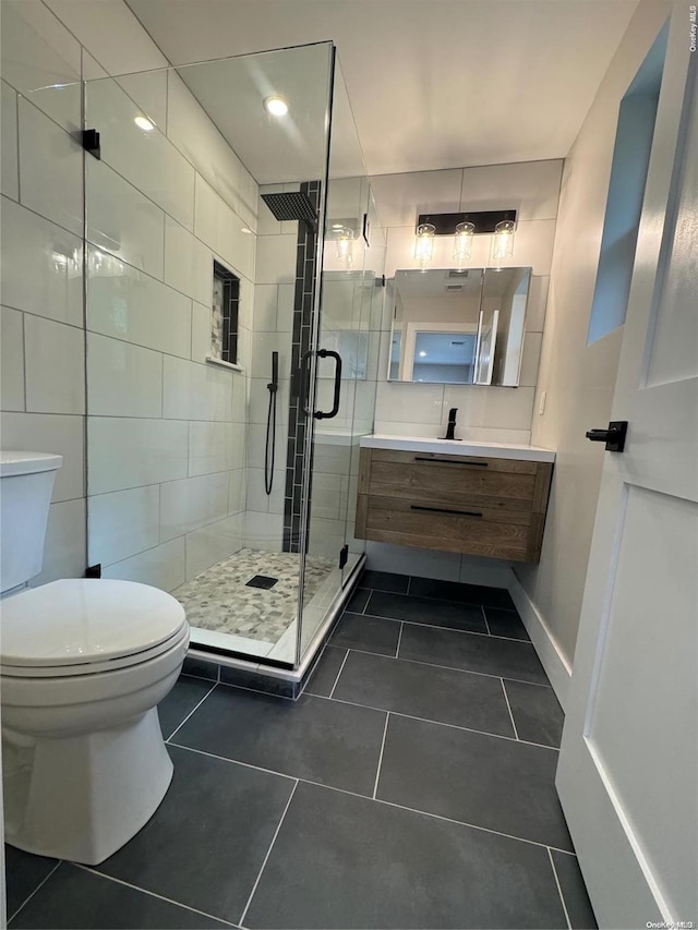 bathroom featuring toilet, vanity, tile patterned floors, and walk in shower